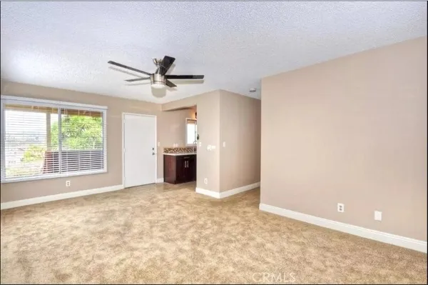 an empty room with windows and ceiling fan
