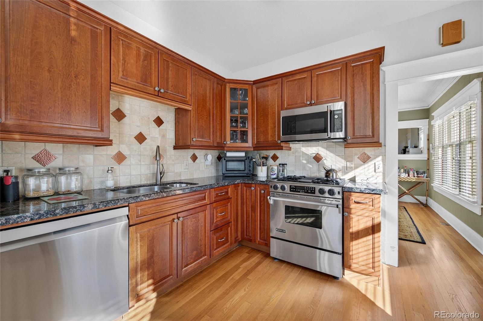 607 Madison Street Denver, CO 80206 - Photo 20 of 31 a kitchen with stainless steel appliances granite countertop a stove a sink and a microwave