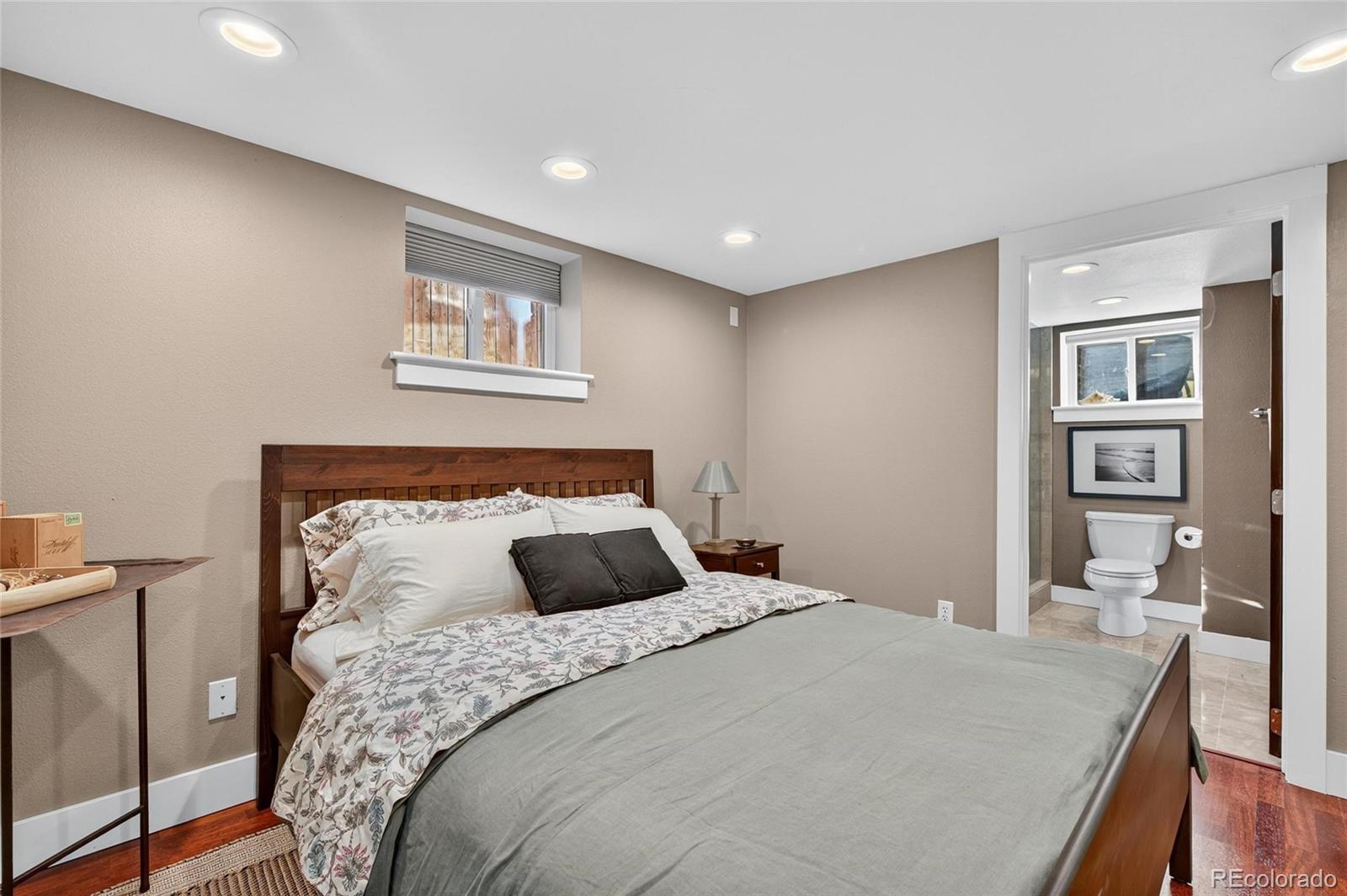 607 Madison Street Denver, CO 80206 - Photo 28 of 31 a bedroom with a large bed and a chandelier