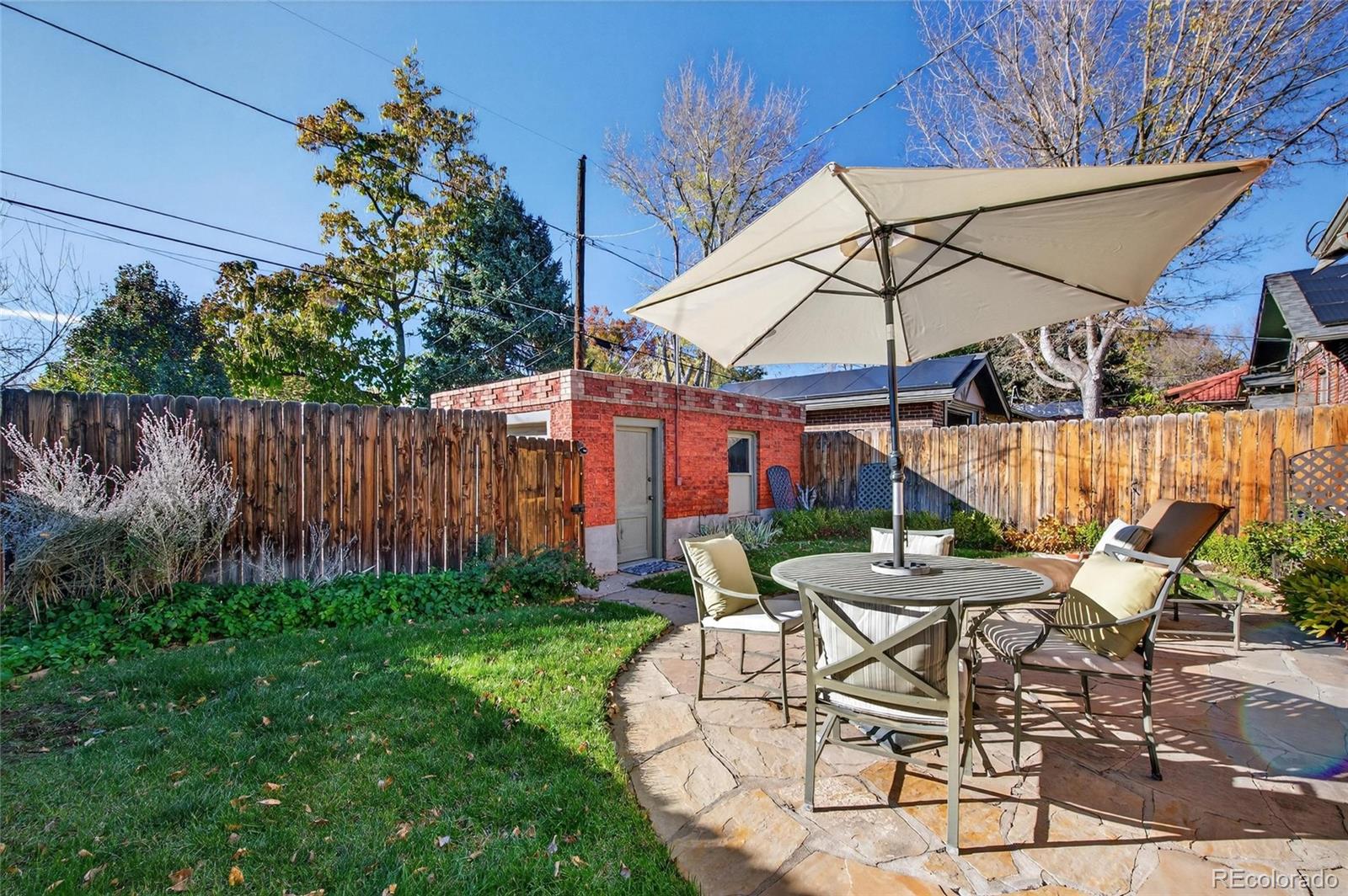 607 Madison Street Denver, CO 80206 - Photo 30 of 31 a patio with a table and chairs under an umbrella