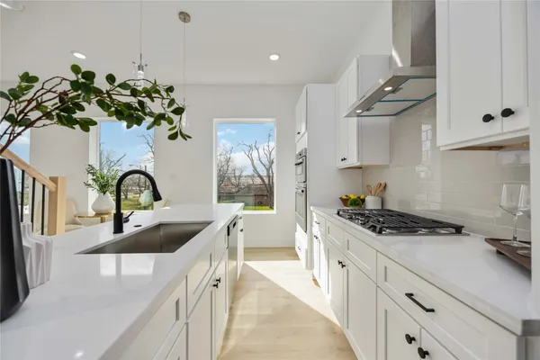 a kitchen with stainless steel appliances a sink a stove and cabinets