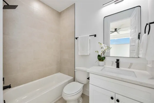 a bathroom with a granite countertop toilet sink and mirror