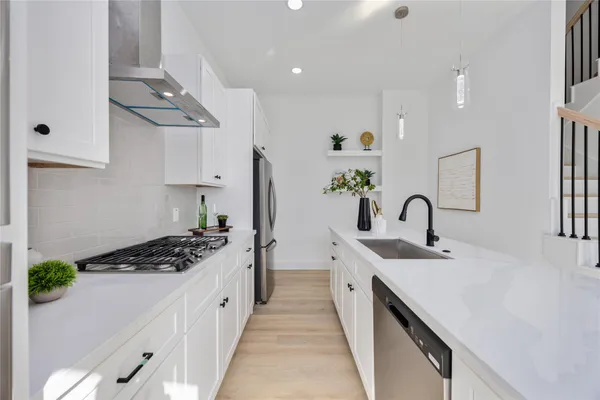a kitchen with stainless steel appliances a sink stove and cabinets
