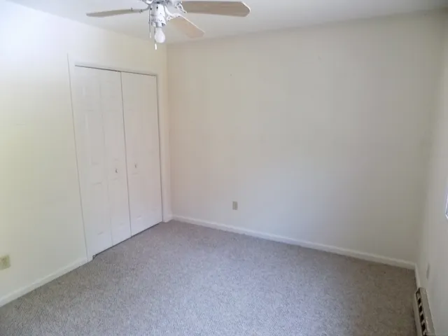 a view of an empty room with a chandelier fan