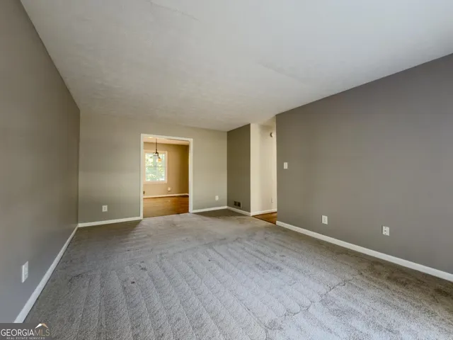 a view of an empty room with window and closet area
