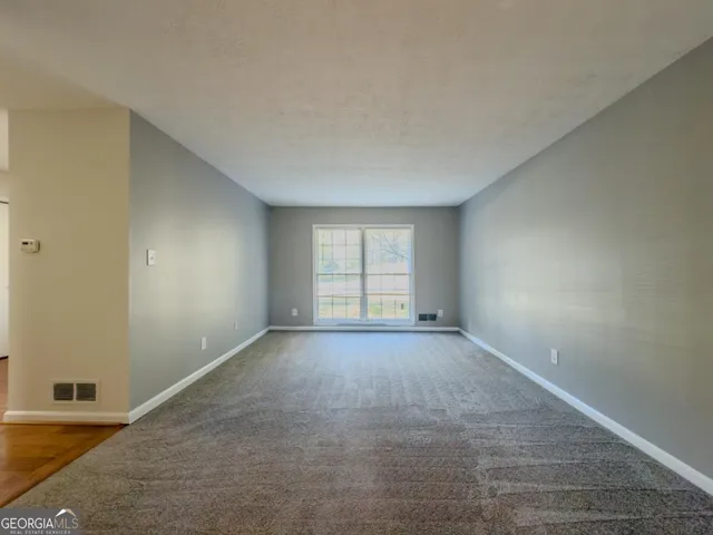 an empty room with windows and closet