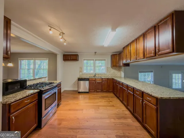 a kitchen with stainless steel appliances granite countertop a stove a sink and a refrigerator