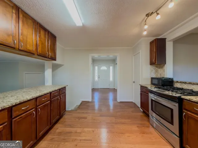 a kitchen with stainless steel appliances granite countertop a stove and a sink