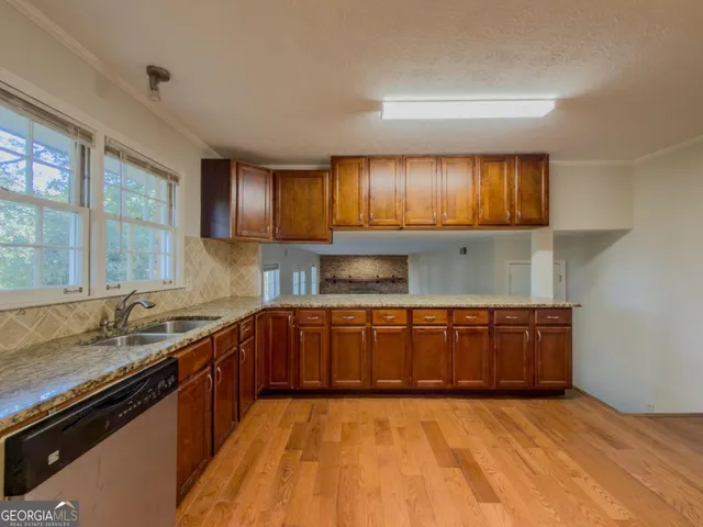 a kitchen with granite countertop a sink stove and cabinets