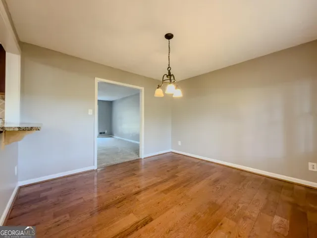 a view of an empty room with a chandelier fan