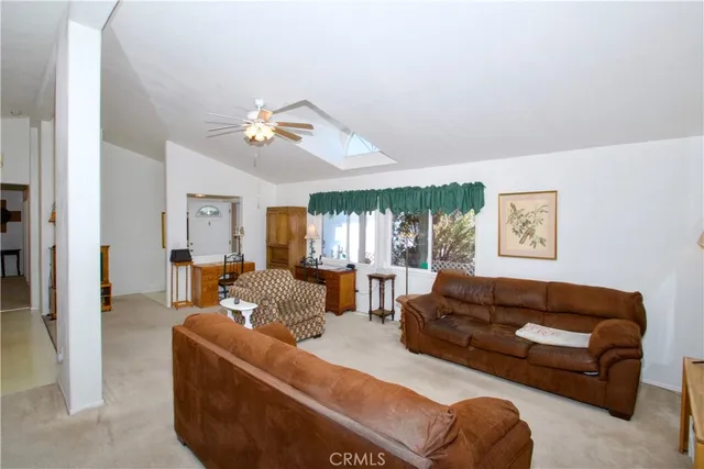a living room with furniture ceiling fan and a window
