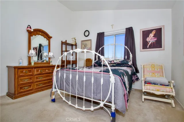 a bedroom with a bed and dresser with mirror