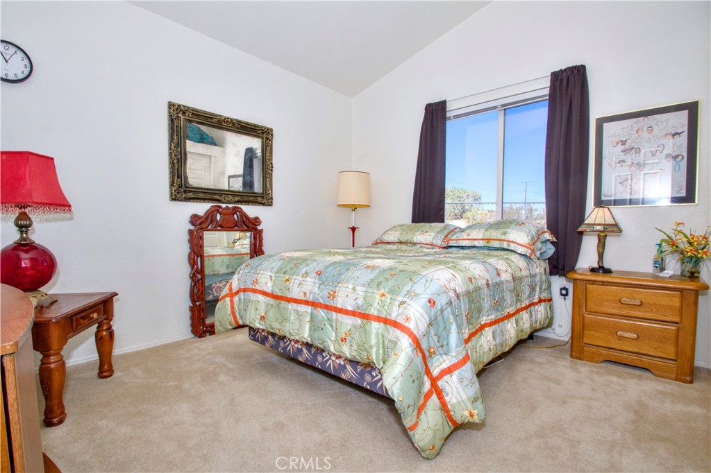 4742 Avenida La Mirada Joshua Tree, CA 92252 - Photo 19 of 45 a bedroom with a bed and dresser with mirror