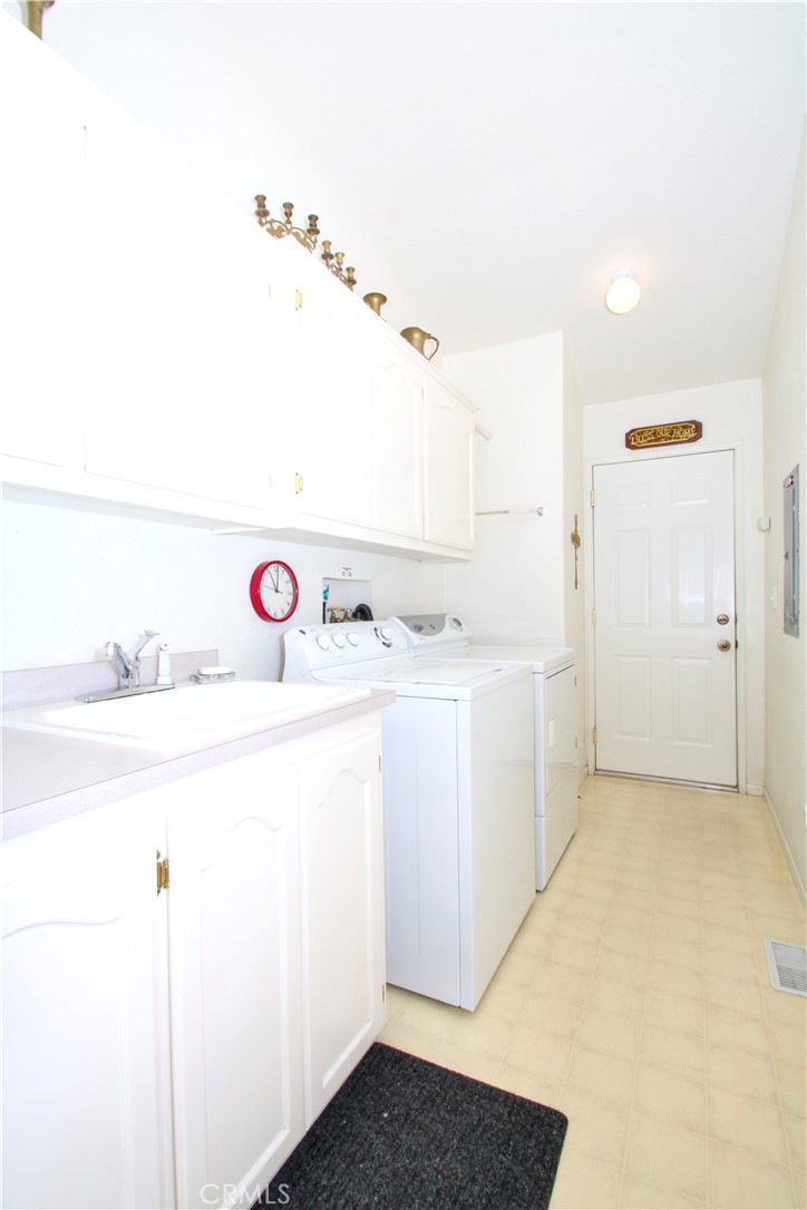 4742 Avenida La Mirada Joshua Tree, CA 92252 - Photo 30 of 45 a utility room with cabinets washer and dryer