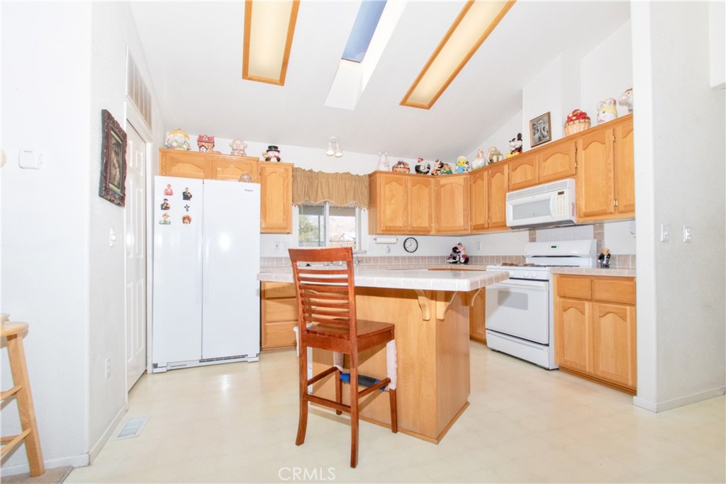 4742 Avenida La Mirada Joshua Tree, CA 92252 - Photo 3 of 45 a kitchen with stainless steel appliances kitchen island granite countertop a refrigerator and a stove top oven