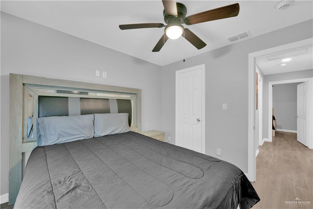 405 East Guerra Street Rio Grande City, TX 78582 - Photo 18 of 33 Bedroom featuring wood finished floors, ceiling fan, and baseboards