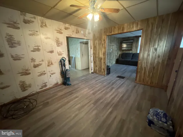 a view of a hallway with wooden floor and a bathroom