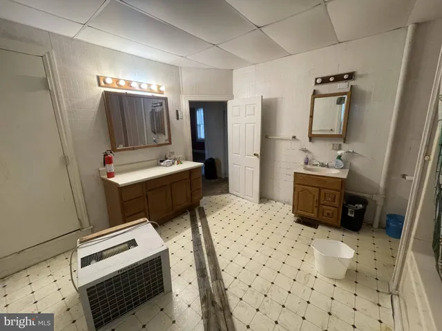 a bathroom with a sink a toilet a mirror and shower