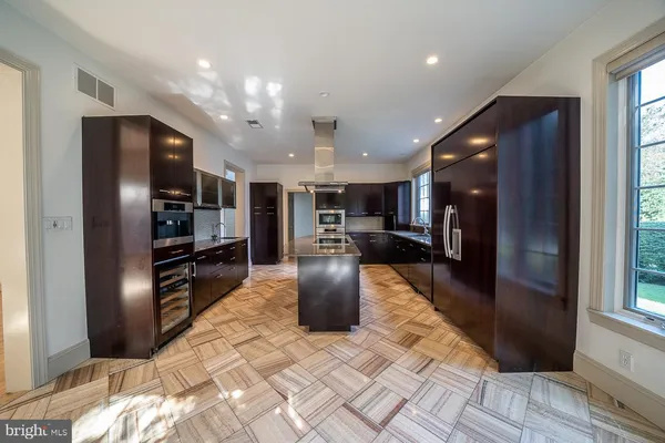 a kitchen with stainless steel appliances kitchen island granite countertop a stove and a refrigerator