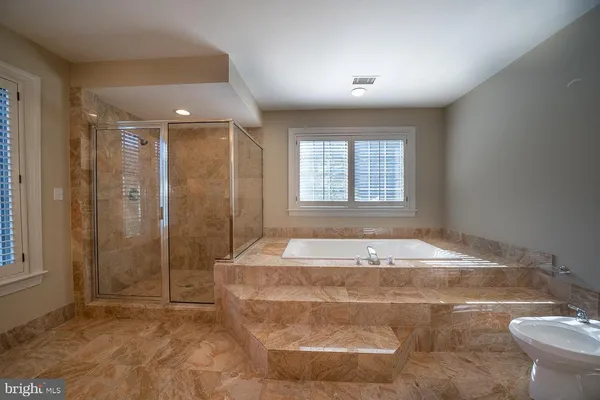 a spacious bathroom with a bathtub and a shower
