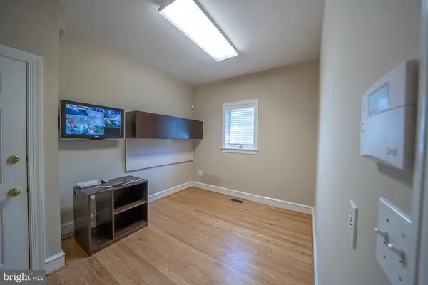 an empty room with wooden floor and staircase