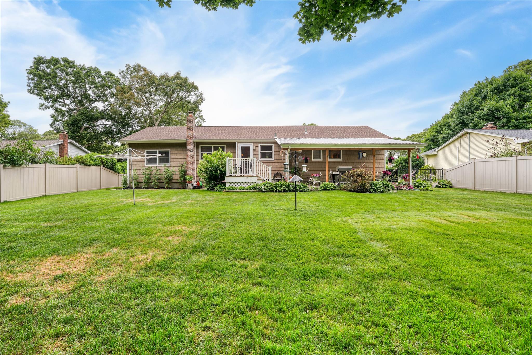 7 Russell Road Hampton Bays, NY 11946 - Photo 23 of 31 Back of house featuring a fenced backyard, a chimney, a wooden deck, and a shingled roof