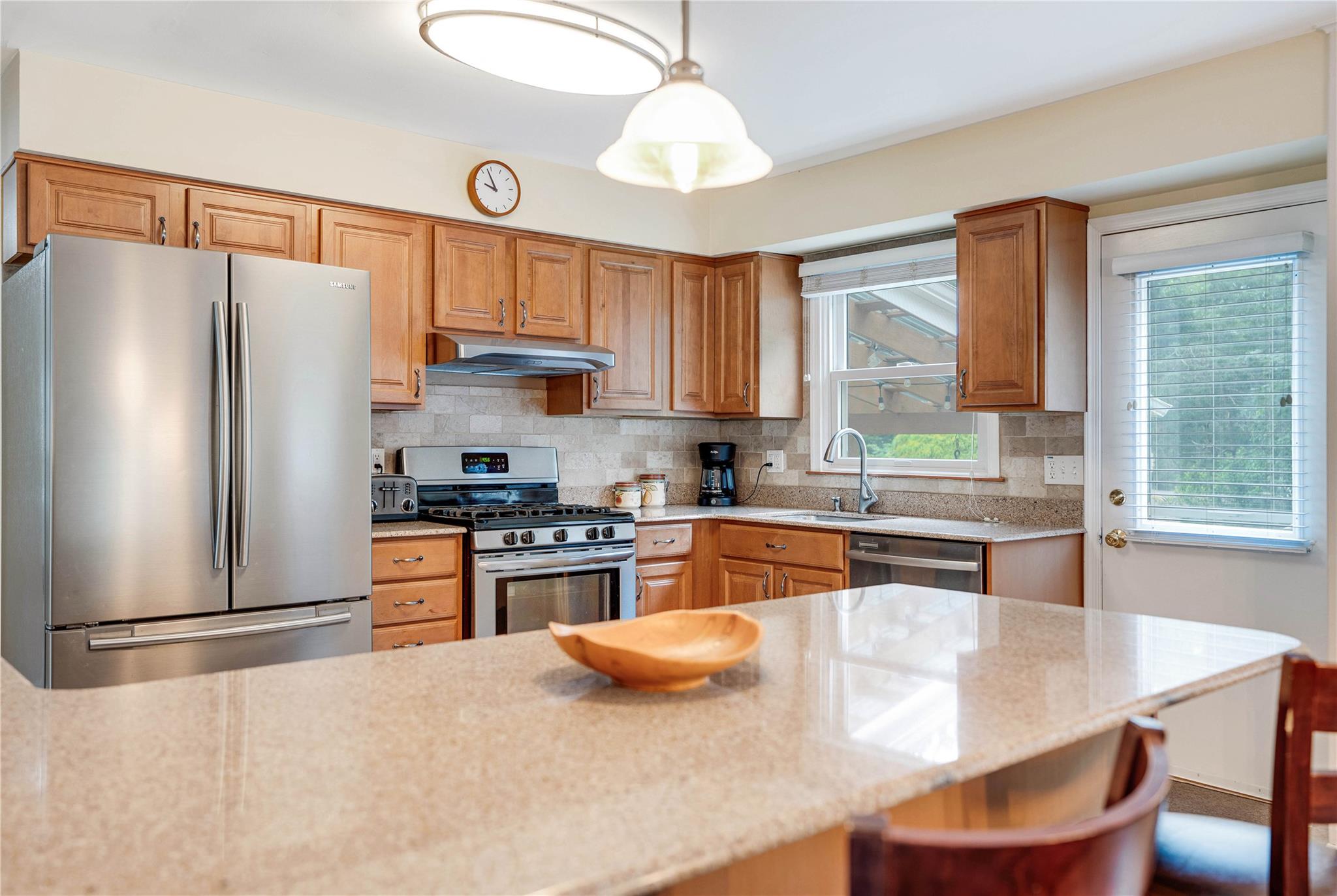 7 Russell Road Hampton Bays, NY 11946 - Photo 26 of 31 Kitchen with stainless steel appliances, a kitchen bar, plenty of natural light, and backsplash