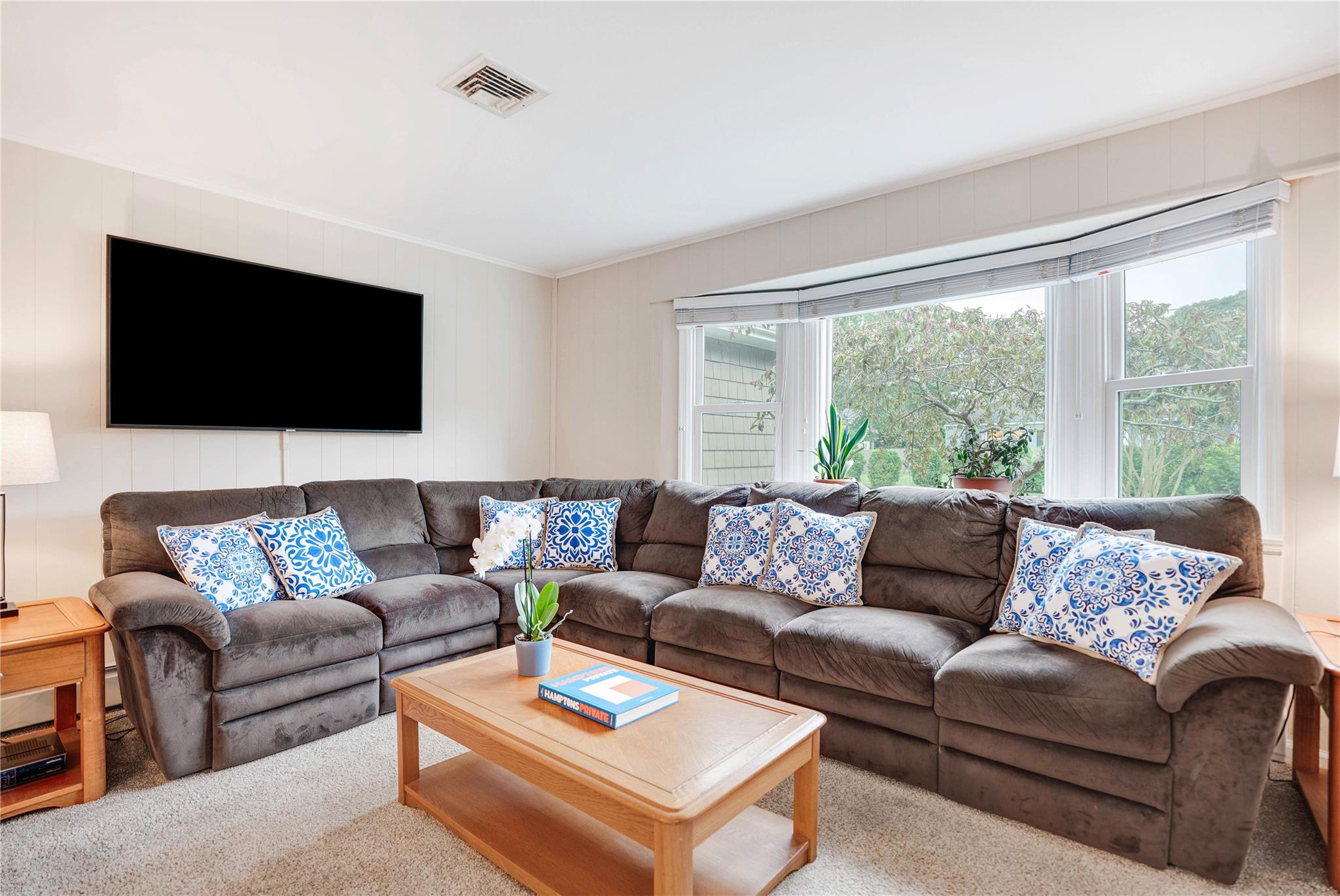 7 Russell Road Hampton Bays, NY 11946 - Photo 29 of 31 Carpeted living room with plenty of natural light and crown molding