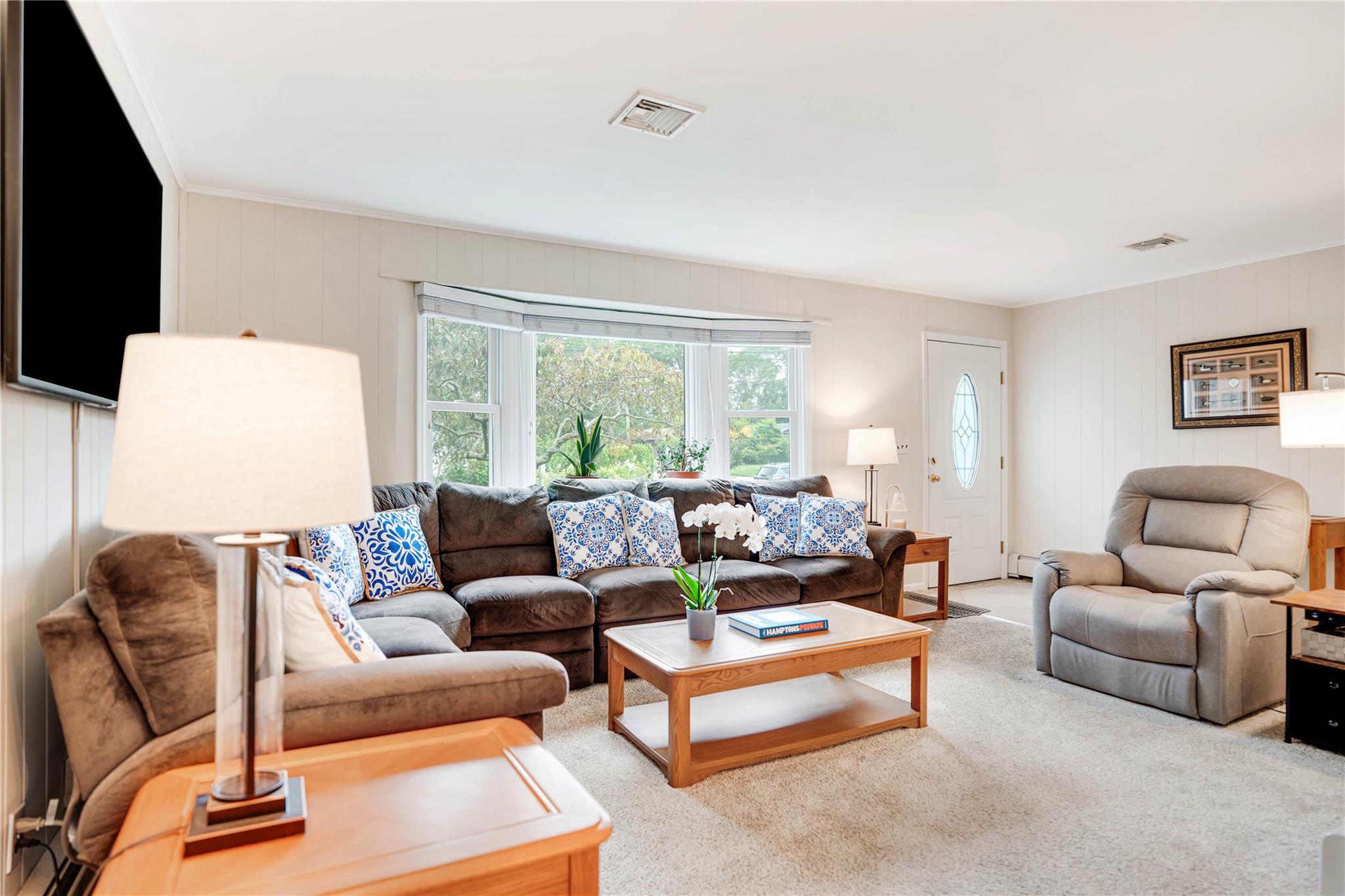 7 Russell Road Hampton Bays, NY 11946 - Photo 30 of 31 Living area featuring carpet and wood walls