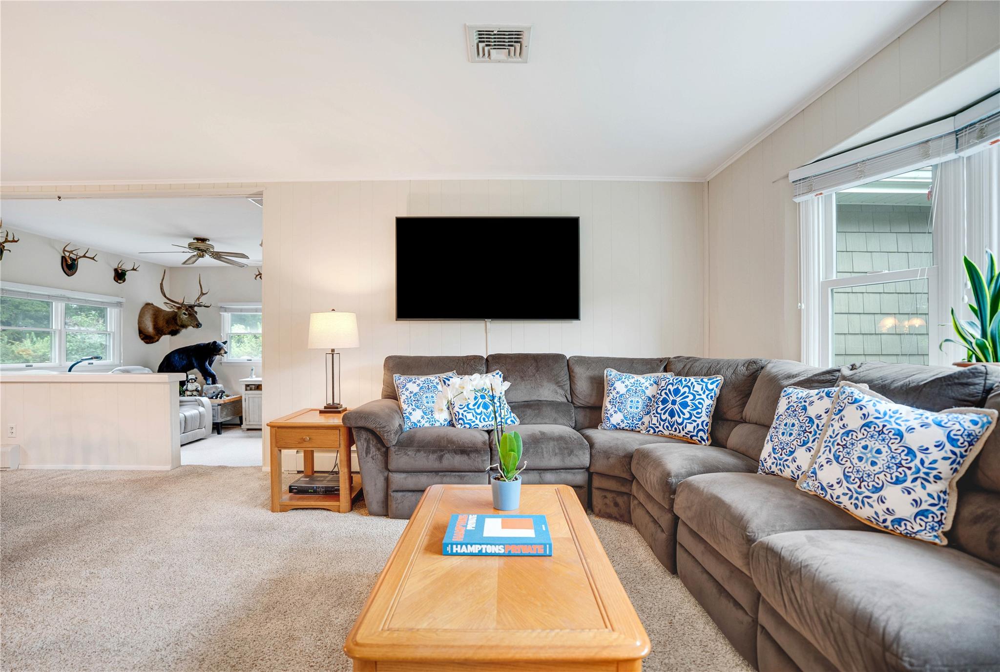 7 Russell Road Hampton Bays, NY 11946 - Photo 3 of 31 Carpeted living area with ceiling fan and ornamental molding