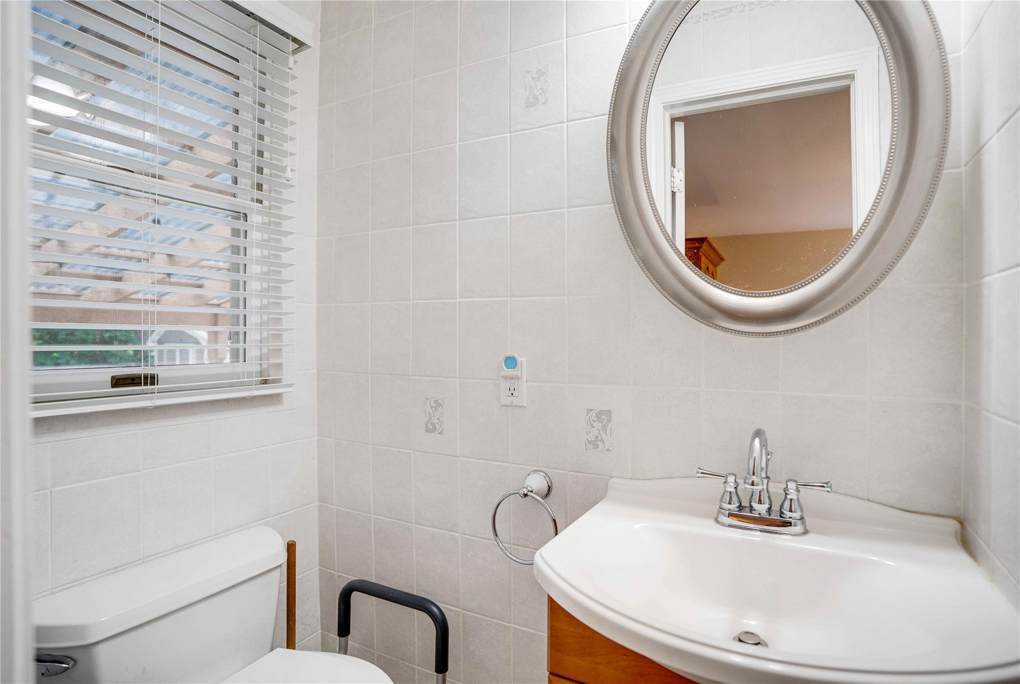7 Russell Road Hampton Bays, NY 11946 - Photo 4 of 31 Half bathroom featuring tile walls and vanity