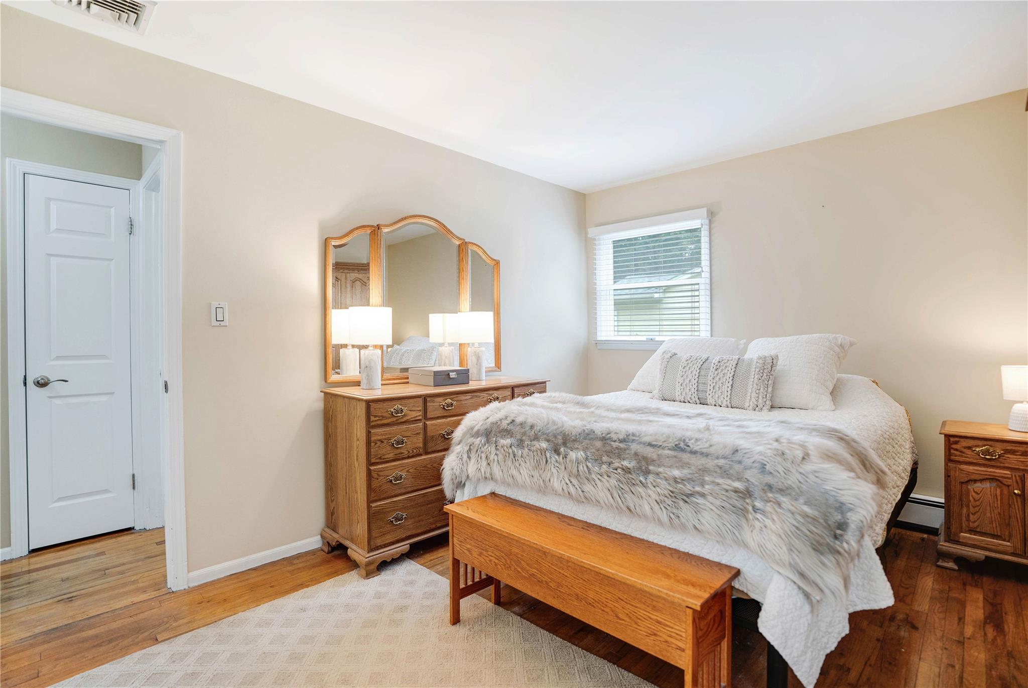 7 Russell Road Hampton Bays, NY 11946 - Photo 9 of 31 Bedroom with light wood-style floors and a baseboard radiator