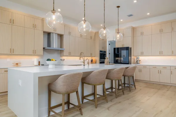 a view of a hallway with wooden floor and a bathroom