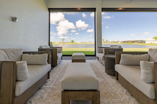 a large white kitchen with a large island oven a stove a sink a dining table and chairs