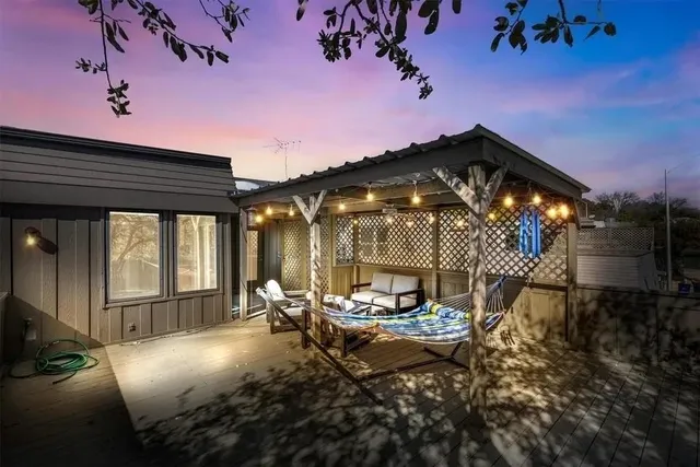 a view of a patio with table and chairs with wooden floor and fence