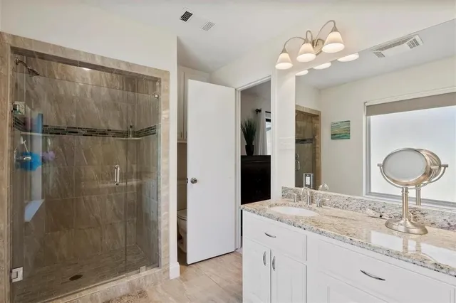 a bathroom with a shower sink and mirror