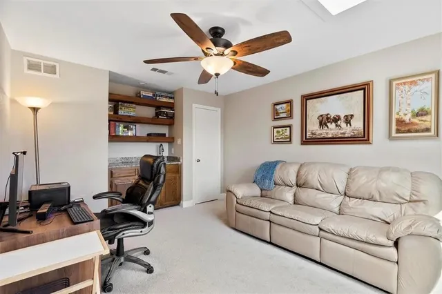 a work room with furniture and a ceiling fan