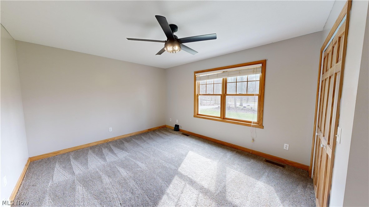 15548 Trask Road Thompson, OH 44086 - Photo 16 of 31 First floor bedroom with light colored carpet and ceiling fan