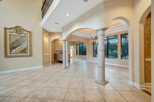 a view of a hallway with entryway and chandelier