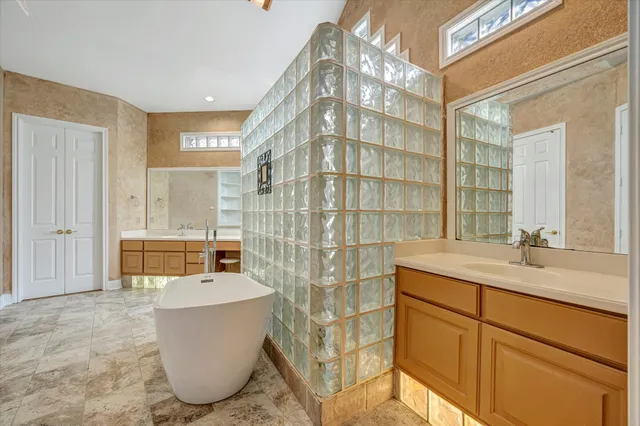 a bathroom with a granite countertop sink and a bathtub