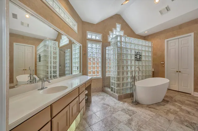 a bathroom with a sink a toilet a mirror and shower