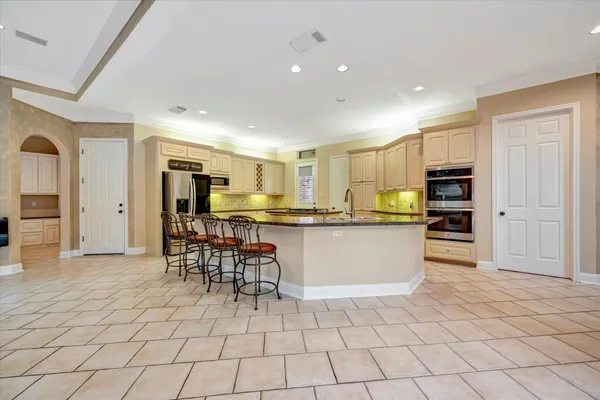 a kitchen with stainless steel appliances kitchen island granite countertop a refrigerator and cabinets