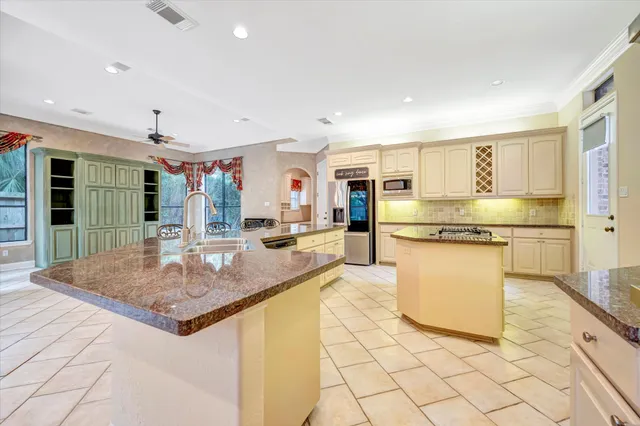 a kitchen with stainless steel appliances granite countertop a sink and a refrigerator