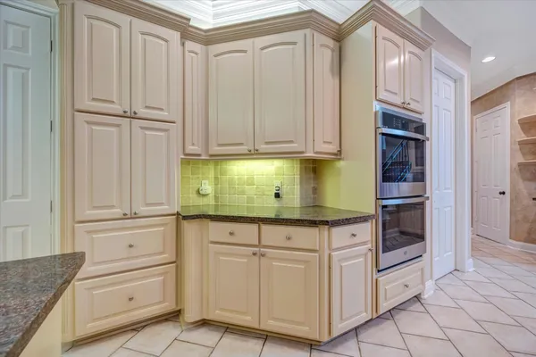 a kitchen with granite countertop white cabinets and stainless steel appliances