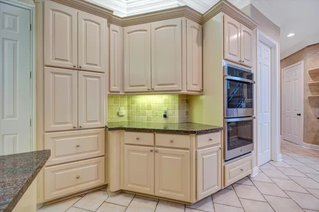 a kitchen with granite countertop white cabinets and stainless steel appliances