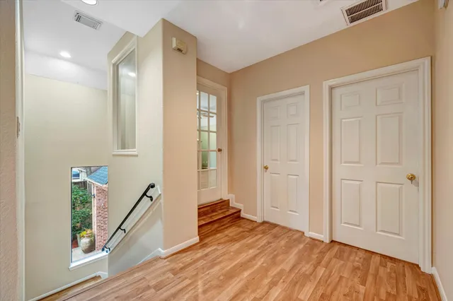 a view of a hallway with bathroom and wooden floor