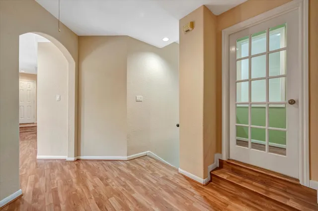 an empty room with wooden floor and windows