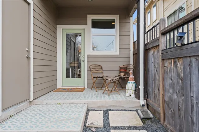 a view of a brick house with a chairs and table in a patio