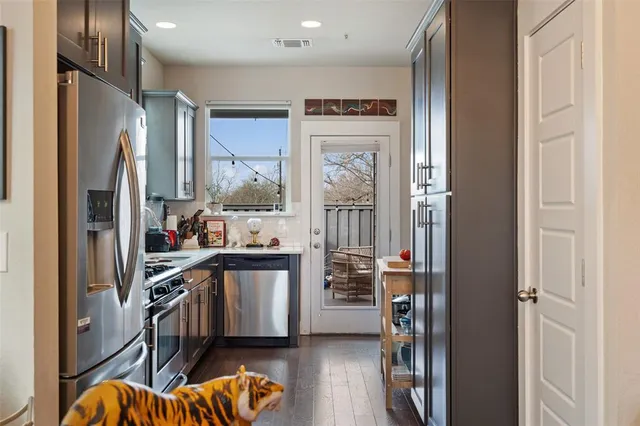 a kitchen with stainless steel appliances a refrigerator and a wooden floor