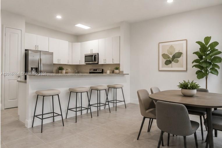 18901 Southwest 316th Street Homestead, FL 33030 - Photo 11 of 33 a kitchen with kitchen island a table and chairs in it
